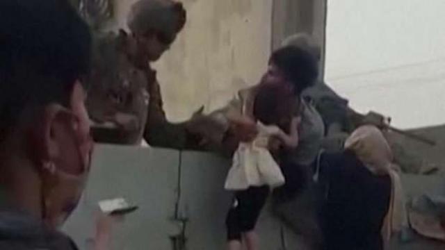 الجندي الأمريكي يتسلم الرضيع الأفغاني