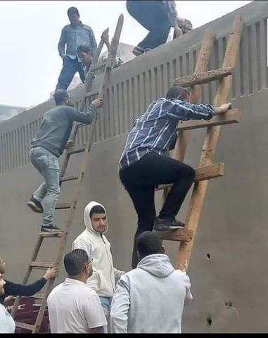 مواطنين يتسلقون السلم الخشبي